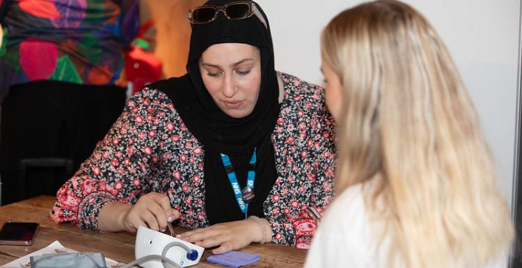 Two women talking over a blood pressure monitor